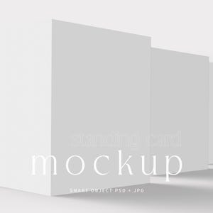 Può includere: Un mockup di tre biglietti bianchi in piedi, disposti in fila, con il testo "standing card mockup" in un carattere chiaro. I biglietti sono su una superficie bianca con ombre morbide.
