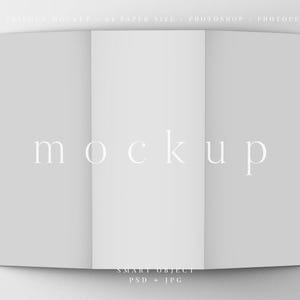 May include: A folded, light gray brochure mockup with the word "mockup" in a delicate, white font. The brochure is open, displaying three panels. The top of the image has text that reads "FOLDED MOCKUP - A4 PAPER SIZE - PHOTOSHOP - PHOTOPEA".
