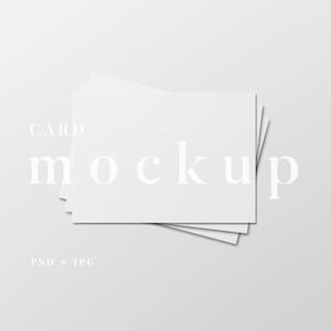 May include: A stack of white rectangular cards arranged on a light gray background. The word "CARD" is above the cards, and the word "mockup" is centered below the cards. The text "PSD + JPG" is at the bottom.