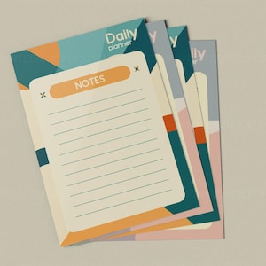 May include: A stack of daily planner notepads with a geometric design. The notepads have a cream-colored background with lined pages and the word "NOTES" in an orange rectangle. The top notepad has the words "Daily planner" in teal.