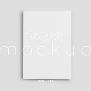 May include: A white paper mockup with the words "paper mockup" in a stylized font. The image is a flat lay on a light gray background. The bottom of the image has the text "PSD + JPG".
