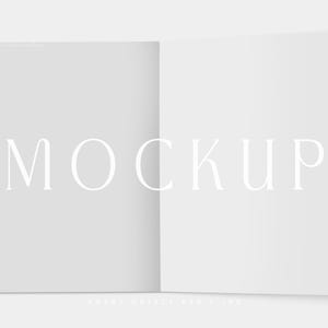 Puede incluir: Una maqueta de un libro o folleto abierto, con la palabra "MOCKUP" en una fuente serif en el centro. Las páginas son blancas y el fondo es gris claro. La parte inferior de la imagen tiene el texto "SMART OBJECT PSD + JPG".