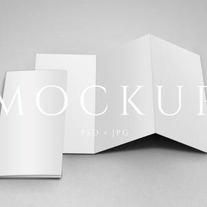 Peut inclure: Maquette de trois brochures blanches pliées sur une surface grise. Les brochures sont disposées dans différentes positions, dont une entièrement ouverte, une partiellement ouverte et une fermée. Le mot "MOCKUP" est affiché en police serif.