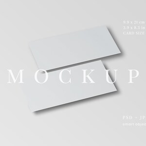 May include: Two white rectangular cards, slightly overlapping, are positioned on a light gray surface. The cards are labeled with the text "MOCKUP". The card size is 3.9 x 8.3 inches. The image also indicates the file types PSD and JPG.