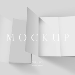 Könnte beinhalten: Ein weißes, gefaltetes Broschüren-Mockup mit dem Wort „MOCKUP“ in einer minimalistischen Schriftart. Die Broschüre ist teilweise geöffnet und zeigt mehrere Tafeln. Das Bild enthält den Text „PSD + JPG“ und „smart object“.