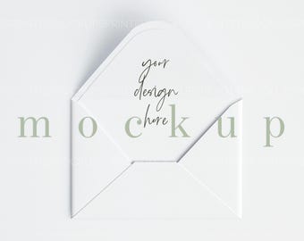 Op de afbeelding: Een witte envelop met een gevouwen flap. De envelop ligt plat op een wit oppervlak. De tekst "your design here" is in zwarte inkt geschreven op de binnenkant van de envelop.