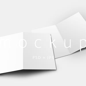 May include: A white, folded brochure mockup with the word "mockup" in a light gray font. The brochure is open, displaying multiple panels. The text "PSD + JPG" is also visible. The background is a solid, light gray.