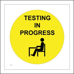 May include: Yellow circular sign with black text that reads "Testing in Progress" and a black silhouette of a person sitting at a desk.