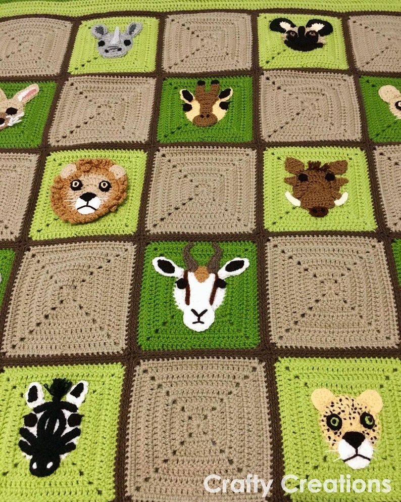 Puede incluir: Una manta de ganchillo con un patr&oacute;n de cuadros verdes y marrones. Cada cuadrado presenta una cara de animal diferente, incluyendo un le&oacute;n, una cebra, una jirafa, un rinoceronte, un guepardo, y m&aacute;s.
