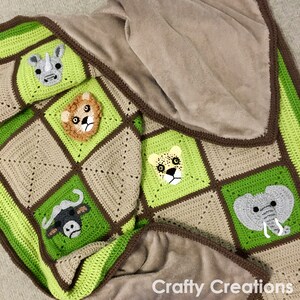Puede incluir: Una manta de beb&eacute; de crochet en color verde, marr&oacute;n y beige. La manta presenta una variedad de caras de animales, incluyendo un rinoceronte, un le&oacute;n, un guepardo, un b&uacute;falo y un elefante. La manta est&aacute; doblada por la mitad y tiene un borde marr&oacute;n.