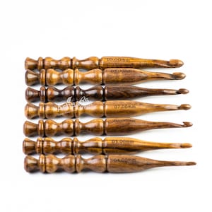 May include: Set of eight wooden crochet hooks with sizes ranging from 4.00mm to 10.00mm. The hooks are made of dark brown wood and have a smooth finish.