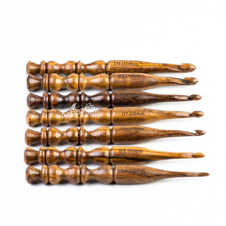 May include: Set of eight wooden crochet hooks with sizes ranging from 4.00mm to 10.00mm. The hooks are made of dark brown wood and have a smooth finish.
