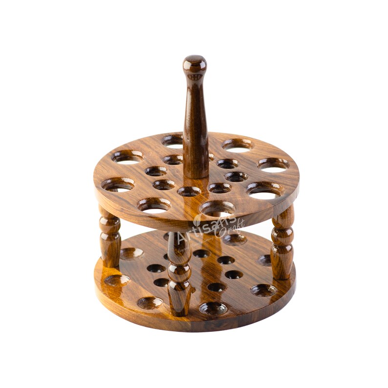 May include: A wooden pipe rack with a round base and a handle. The rack has 24 holes for pipes and is made of dark brown wood.