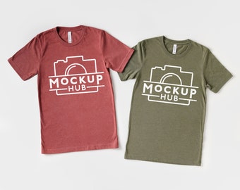 May include: Two t-shirts, one red and one green, with a white camera graphic and the text "MOCKUP HUB" on the front.