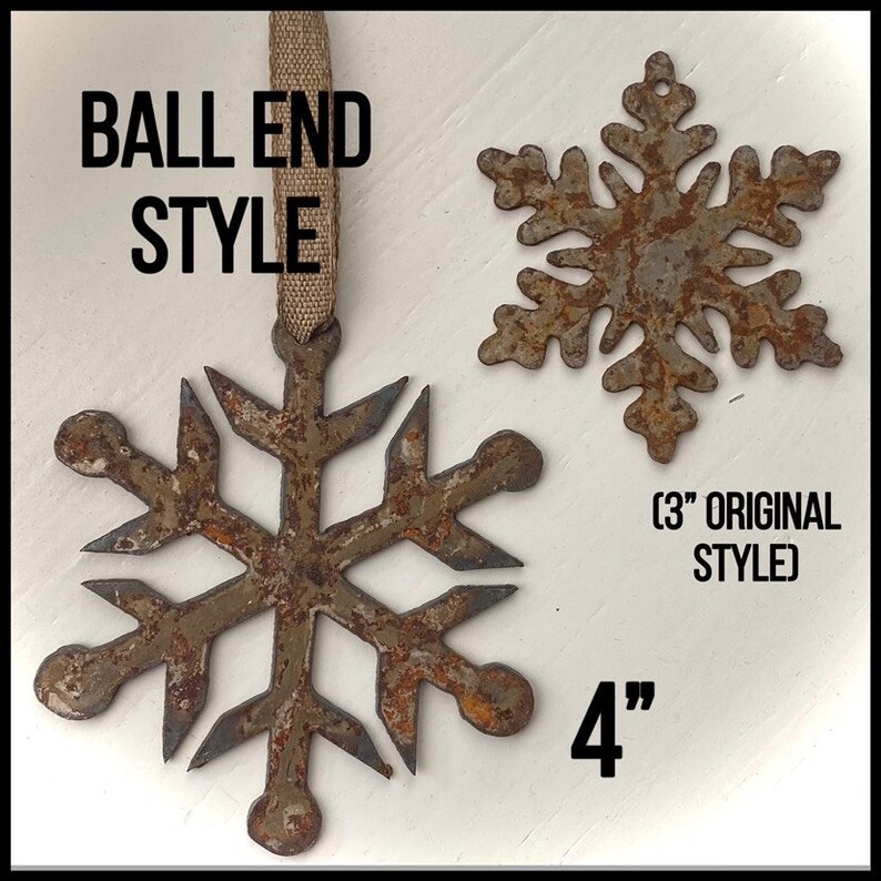 May include: Two rustic metal snowflake ornaments. One is 4 inches in diameter with a ball end style, and the other is a 3-inch original style. Both have a distressed, brown and gray finish, and are suspended by a burlap ribbon.