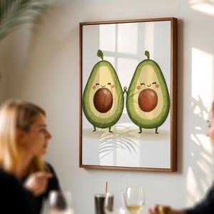 Könnte beinhalten: Eine gerahmte Illustration von zwei Cartoon-Avocados, die sich an den Händen halten. Die Avocados sind grün mit braunen Kernen und haben lächelnde Gesichter. Der Hintergrund ist weiß mit einem hellbraunen Rahmen.