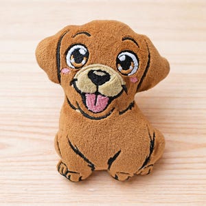 May include: A brown plush puppy dog toy with embroidered features. The toy has large eyes, a smiling mouth with a pink tongue, and small, rounded ears. The puppy is sitting upright, with its paws visible.