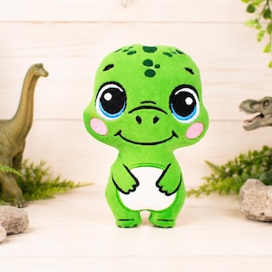 May include: A plush green dinosaur toy with large blue eyes, pink cheeks, and a white belly. The toy is surrounded by toy dinosaurs and greenery, creating a playful, prehistoric theme.