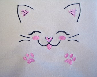 May include: A light beige fabric with an embroidered cat face design. The cat face features black whiskers, eyes, and ear outlines, with pink accents on the ears, cheeks, nose, and paw prints.