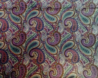 May include: A close-up of a fabric with a repeating paisley pattern. The design features swirling, teardrop-shaped motifs in shades of purple, teal, and burgundy, set against a cream-colored background. The fabric has a vintage aesthetic.