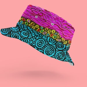 May include: A colorful bucket hat with a pink, blue, and yellow patterned design. The hat has a wide brim and a flat crown.