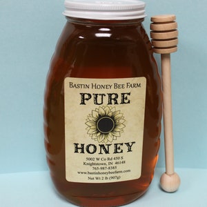 2 lb Local Indiana honey in a glass jar with a wooden honey dipper
