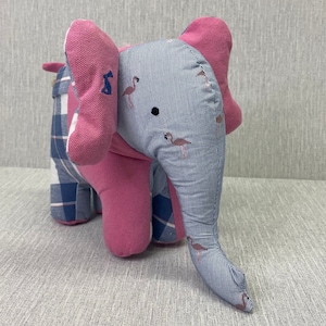 May include: A pink and blue patchwork elephant stuffed animal with a striped pattern and flamingo designs.