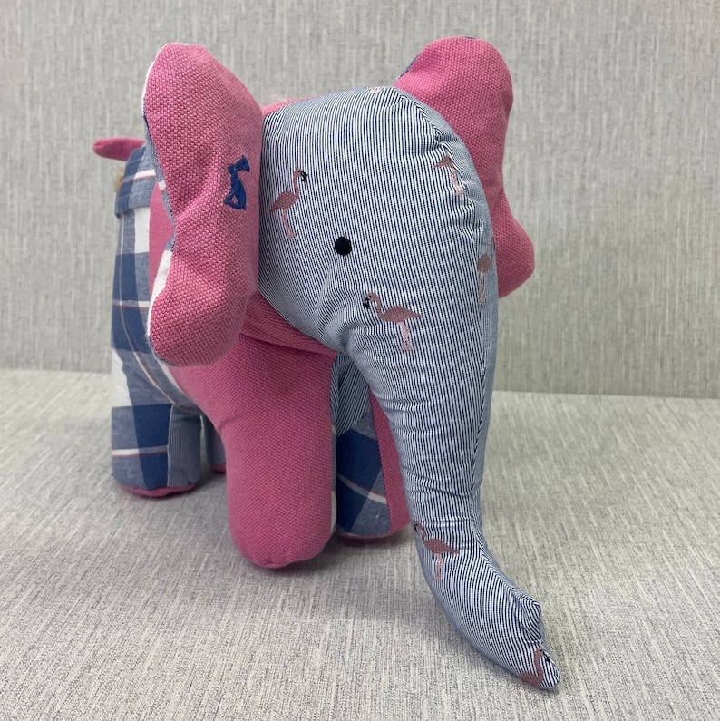 May include: A pink and blue patchwork elephant stuffed animal with a striped pattern and flamingo designs.