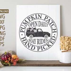 May include: Black and white sign with a circle design that says "Pumpkin Patch, Open Daily, Hay Rides, Hand Picked". A black pickup truck with pumpkins in the bed is in the center of the circle.