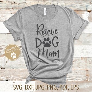 Pu&ograve; includere: Maglietta grigia con il testo "Rescue Dog Mom" e una grafica di impronta di zampa. Il testo "Donates to Rescues" &egrave; in un cerchio con una grafica di impronta di zampa.