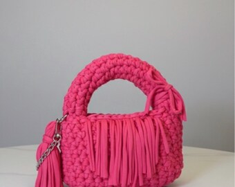 Monedero rosa brillante de ganchillo hecho a mano: asa gruesa, borla de algodón y detalle de cadena plateada.