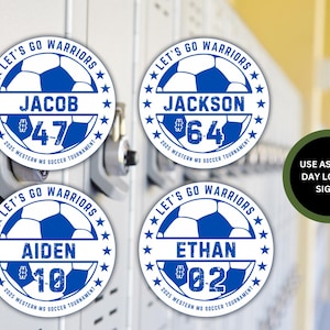 May include: Four white circular stickers with blue soccer balls and white stars around the edge. Each sticker has a name, number, and the text "Let's Go Warriors" and "2025 Western MS Soccer Tournament". The text "Use as Game Day Locker Signs" is on a green background.
