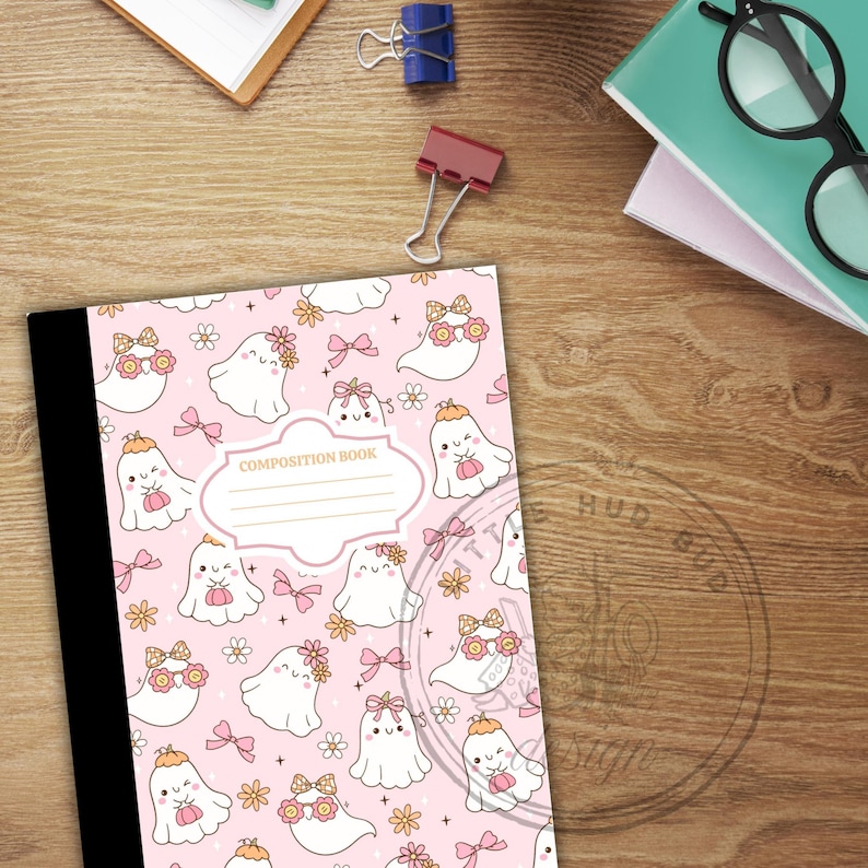 May include: A composition book with a pink cover featuring a pattern of cute ghost illustrations with flowers and bows. The words "COMPOSITION BOOK" are printed on the cover. The book has a black spine.