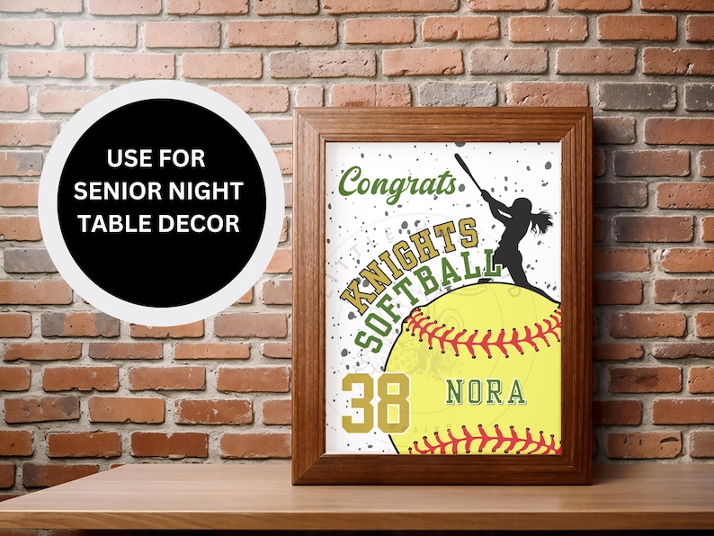 May include: A brown picture frame with a white background and a softball graphic. The softball is yellow with red stitching and has the text "Congrats Knights Softball 38 NORA" on it.