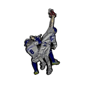 May include: A metal enamel pin depicting two baseball players in white and blue uniforms. One player wears number 8 with the name HERNÁNDEZ, while the other wears number 44. The players are shown in a dynamic action pose, with one reaching up.