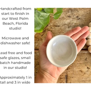 May include: A small, white ceramic bowl, approximately 1 inch tall and 3 inches wide. The bowl is handmade and food safe.