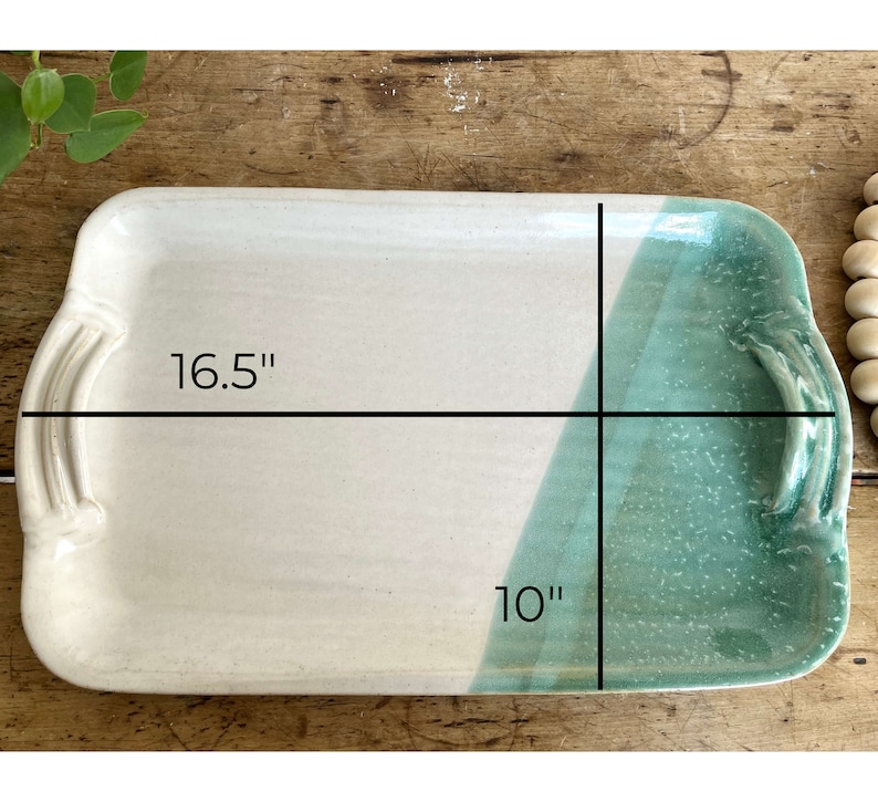 May include: A rectangular ceramic serving tray with a white glaze and a green glaze on one side. The tray measures 16.5 inches by 10 inches.