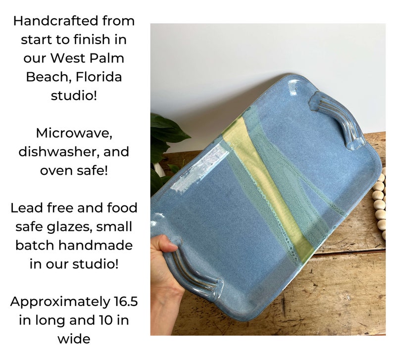 May include: A blue ceramic serving tray with yellow and green glaze accents. The tray has two handles and measures approximately 16.5 inches long and 10 inches wide. It is handcrafted in West Palm Beach, Florida and is microwave, dishwasher, and oven safe.