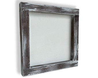 May include: A whitewashed wood picture frame with a distressed finish. The frame has a raised, textured border.