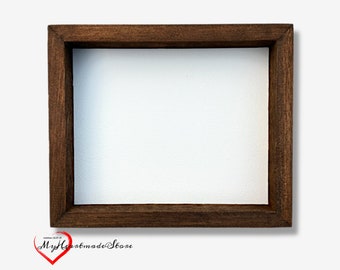 May include: A brown wooden frame with a white background. The frame is approximately 8 inches by 10 inches.