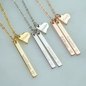 May include: Four gold, silver, and rose gold necklaces with personalized bar pendants and heart charms. The pendants are engraved with the names "William", "Olivia", "Ethan", and "Kayden". The heart charms are engraved with the words "Mom", "Grandma", "Aunt", and a heart symbol.