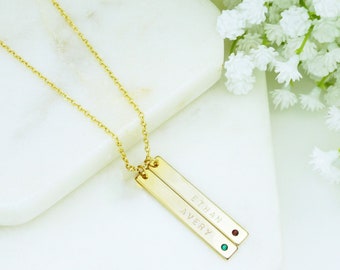 May include: Gold bar necklace with two personalized nameplates, "ETHAN" and "AVERY", and red and green gemstones.
