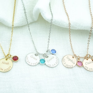 May include: Four personalized necklaces with round silver, gold, and rose gold pendants. Each pendant has a name and date engraved on it. The necklaces are adorned with small colorful gemstones.