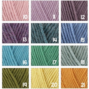 Op de afbeelding: Een verzameling van 18 garenklossen in verschillende kleuren, waaronder wit, beige, roze, paars, blauw, groen, geel, oranje en rood. De klossen zijn gerangschikt in een rasterpatroon, waarbij elke klos is genummerd van 7 tot 24.