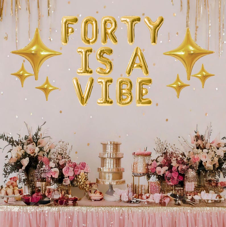 May include: A pink and gold birthday party table setting with a banner that reads "Forty is a Vibe". The table is decorated with flowers, candles, and a tiered cake stand.
