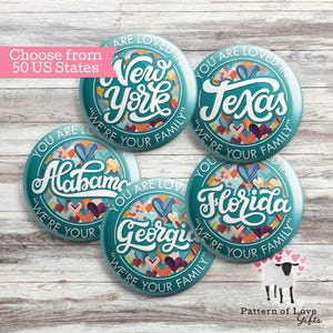May include: A collection of teal-colored round buttons featuring various US state names in white script. Each button has a heart-filled design and the phrase "YOU ARE LOVED IN" and "WE'RE YOUR FAMILY". The text "Choose from 50 US States" is also visible.