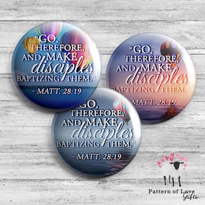 May include: Three round buttons with a blue sky and water reflection background. Each button features a hot air balloon design and the text "Go, therefore, and make disciples baptizing them." - Matt. 28:19