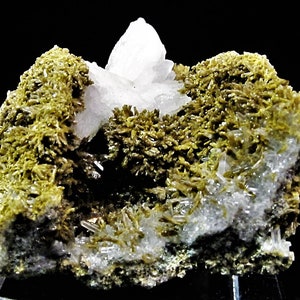 May include: A cluster of clear quartz crystals surrounded by green epidote crystals. The quartz crystals have a glassy lustre. The epidote crystals are a deep green colour and have a rough texture.