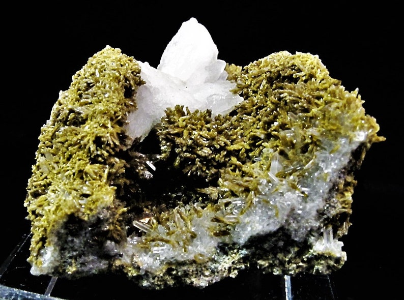 May include: A cluster of clear quartz crystals surrounded by green epidote crystals. The quartz crystals have a glassy lustre. The epidote crystals are a deep green colour and have a rough texture.