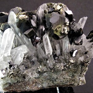 May include: A cluster of black and silver crystals with a clear quartz matrix. The crystals are arranged in a natural, organic pattern, creating a visually appealing and unique specimen.